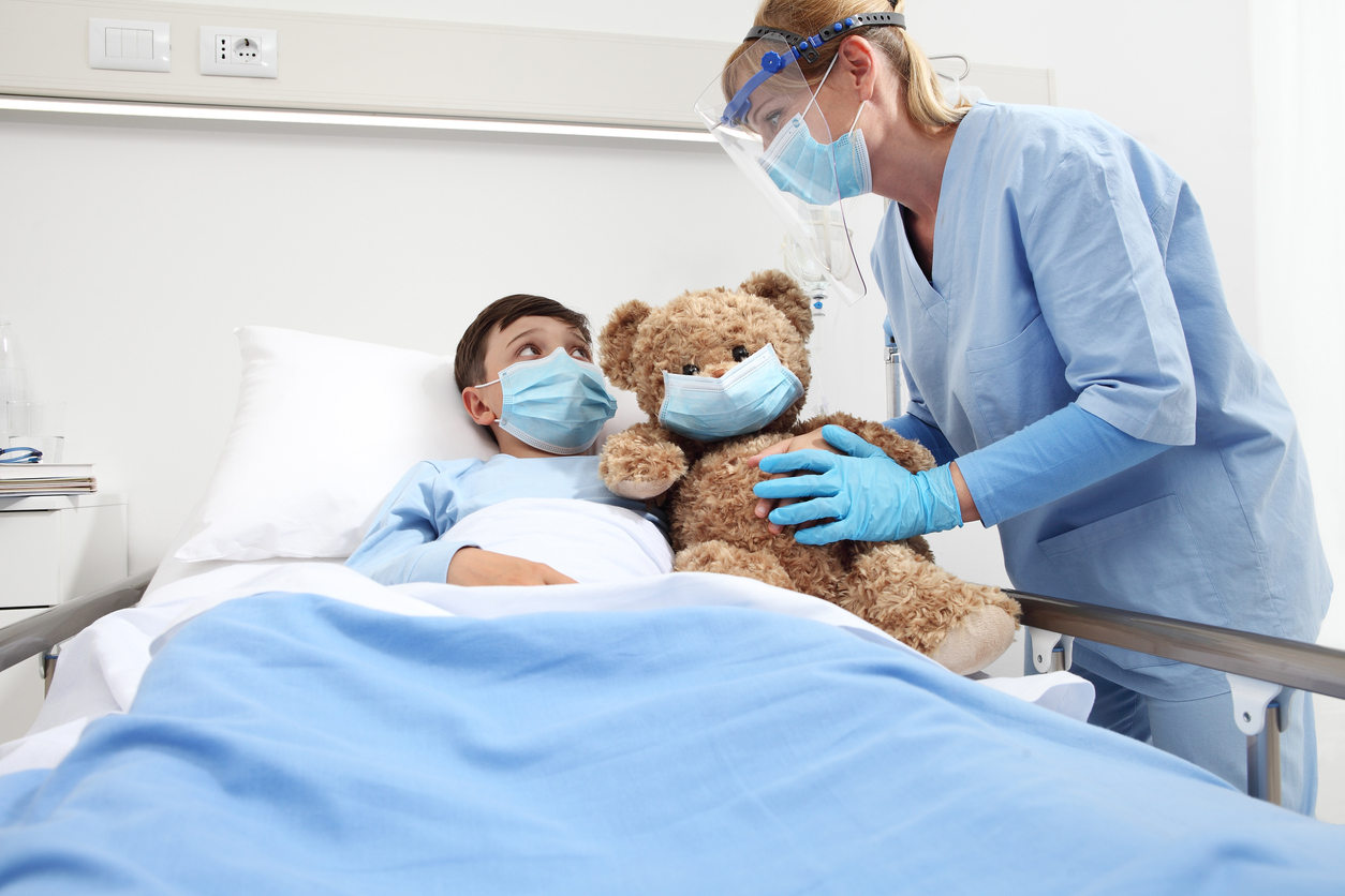 copil cu masca in pat de spital consultat de un medic