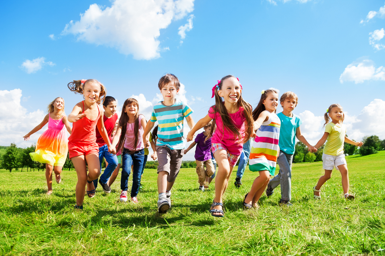 copiii care alearga pe iarba in aer liber