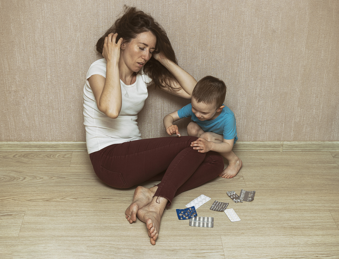 copil si mama stand pe podea tinandu-se cu mainele de cap