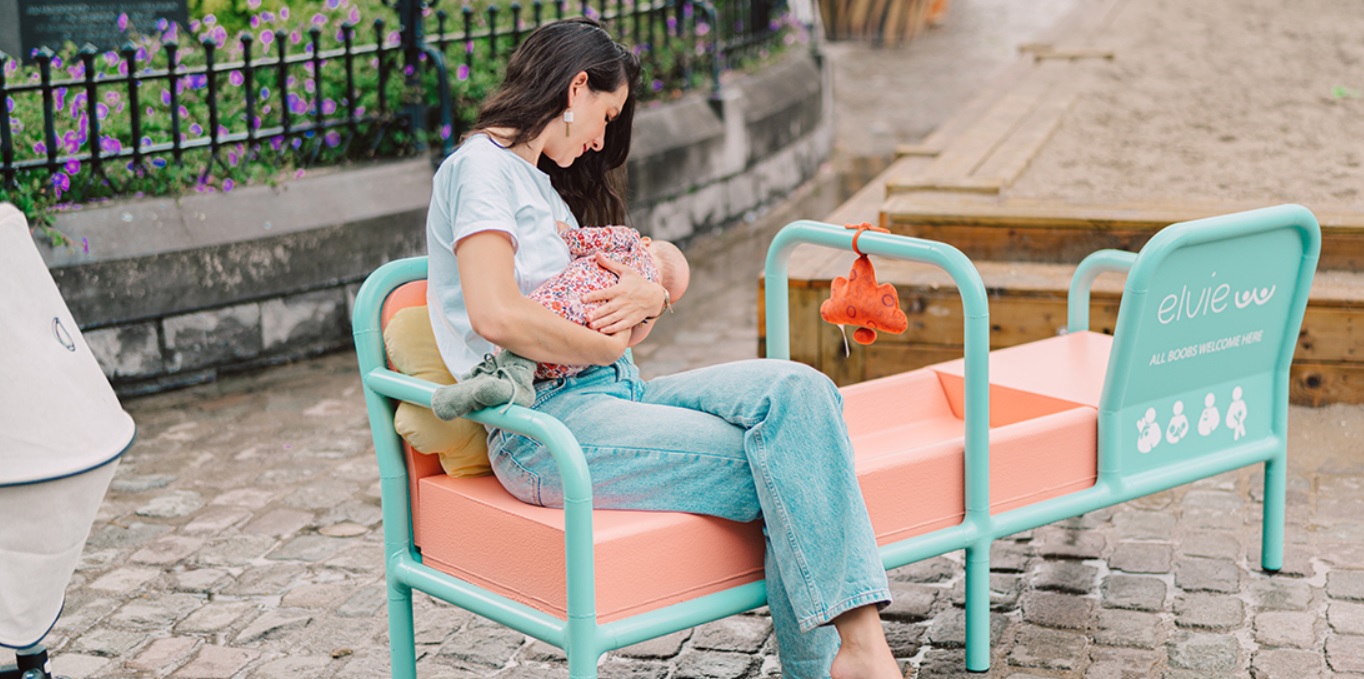 mama care isi alapteaza bebelusul pe o banca de alaptare