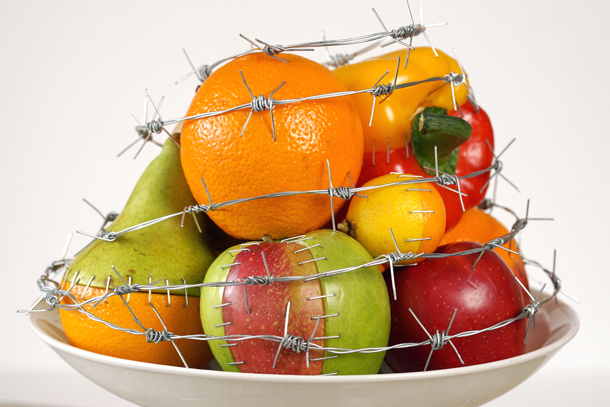 fructe si legume intr-un bol cu pesticide si modificate genetic