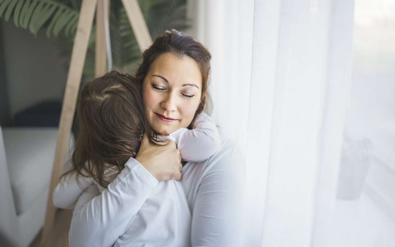 mama care isi imbratiseaza copilul