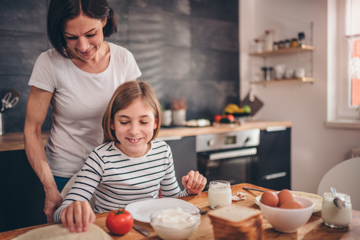 mama si fiica mancand micul dejun la masa din bucatarie