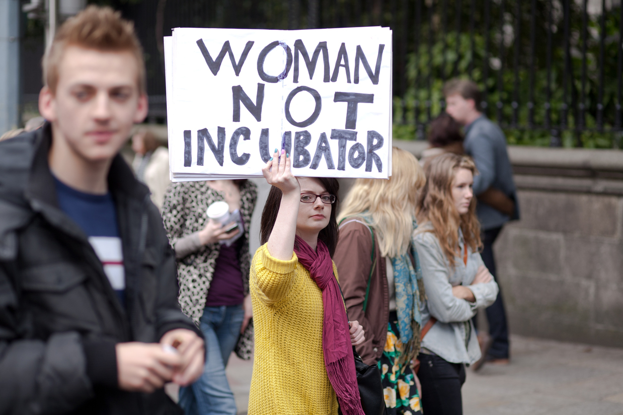 femeie care tine in mana o pancarta pro-avort