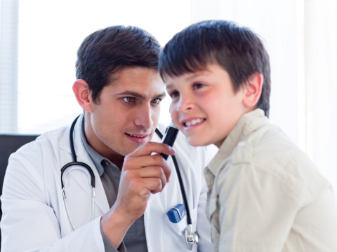 Medic ORL consultand un copil