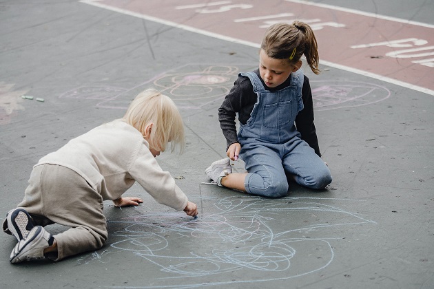 copii care deseneaza cu creta pe asfalt