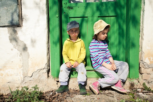 copii care stau pe treapta la intrare in casa