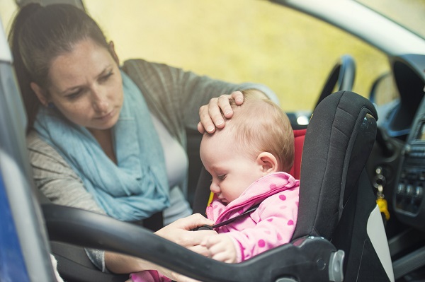 mama trage fermoarul gecutei fetitei in scaunul de masina