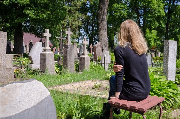 femeie sta pe scaun in cimitir