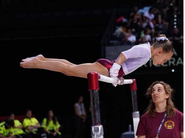 gimnasta lucreaza la aparat cu antrenoarea ei