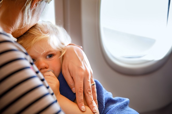 mama tine copil in brate in avion