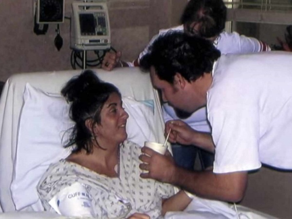femeie pe patul de spital hranita cu lingurita