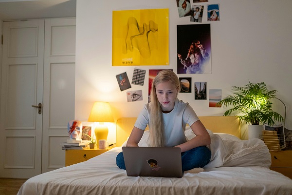 fata sta pe laptop in pat