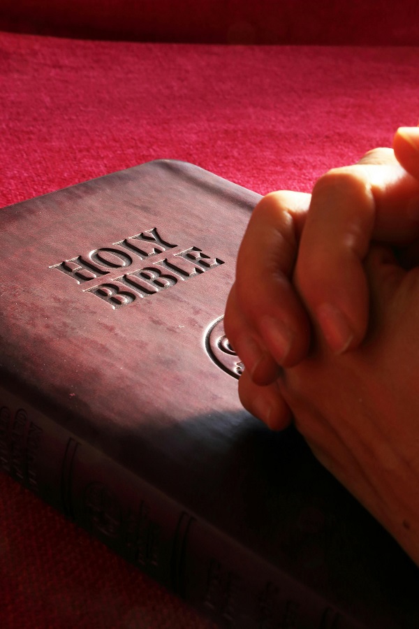 maini in rugaciune peste o biblie