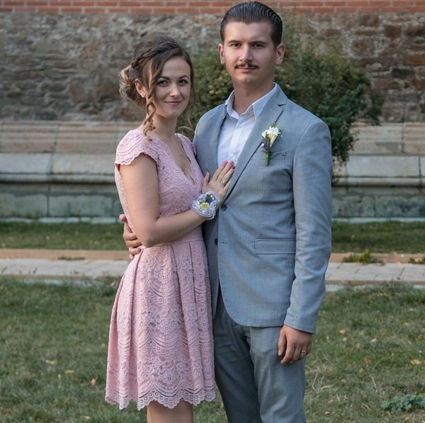 sot imbracat in costum albastru si sotie imbracata in rochie roz