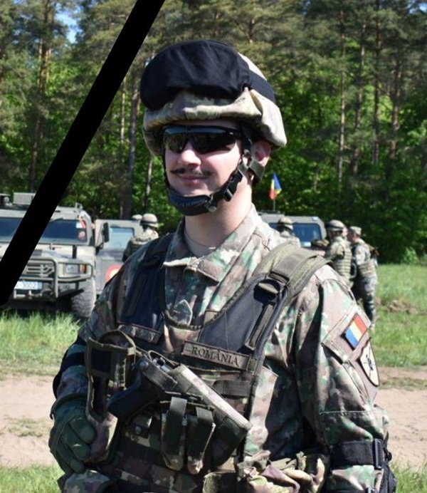 militar imbracat in haine cu casca pe cap si ochelari de soare la ochi