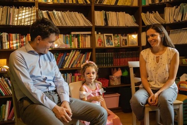 nicusor dan si sotia lui impreuna cu fiica lor intr-o biblioteca