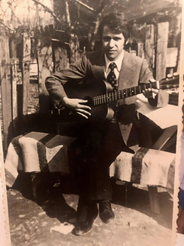 poza veche cu un barbat care canta la chitara