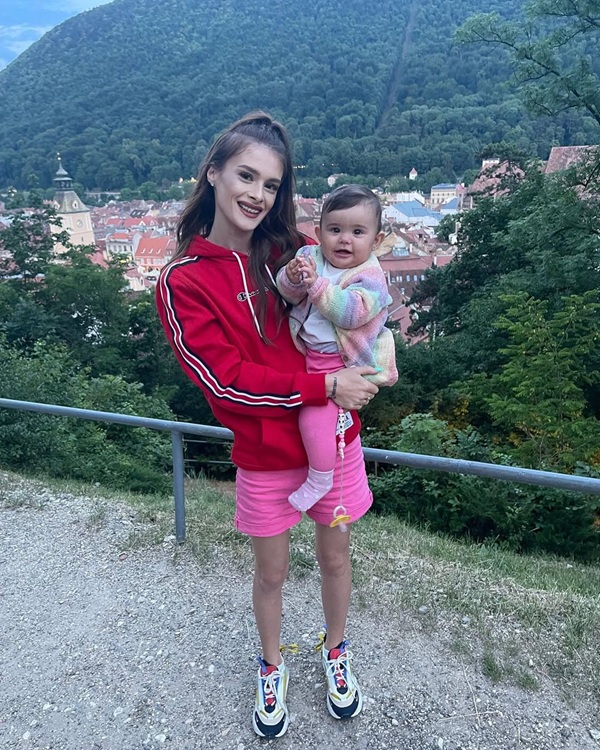teodora marcu imbracata in roz cu fiica ei in brate