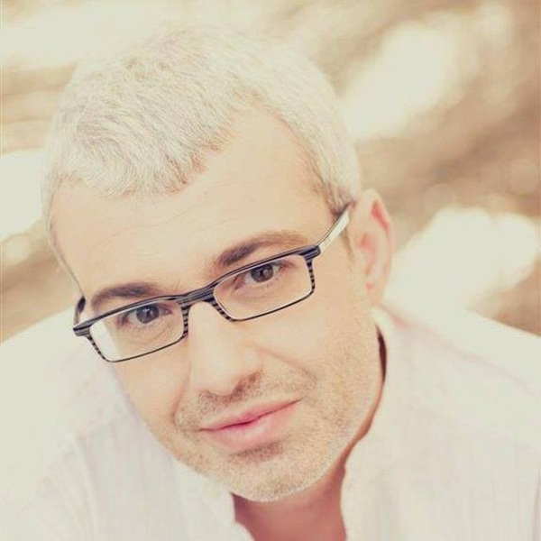 catalin crisan imbracat in alb cu ochelari de vedere cu rama neagra la ochi