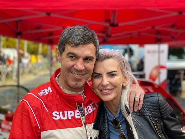 mihai leu in costum rosu de raliuri isi tine sotia de gat