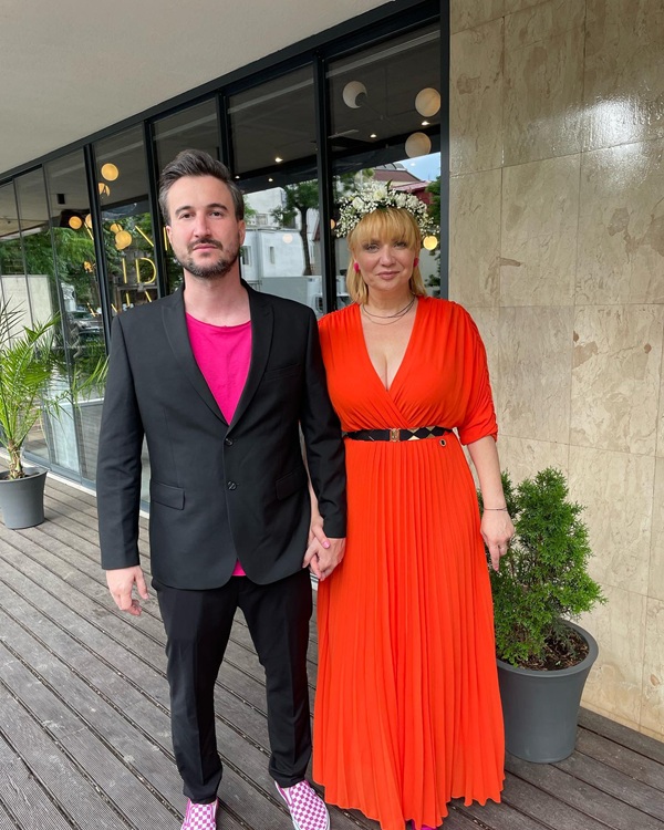 cristina cioran imbracata in rochie rosie alaturi de alex dobrescu in costum negru