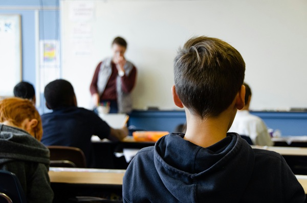 baiat sta in banca la ore atent la profesor