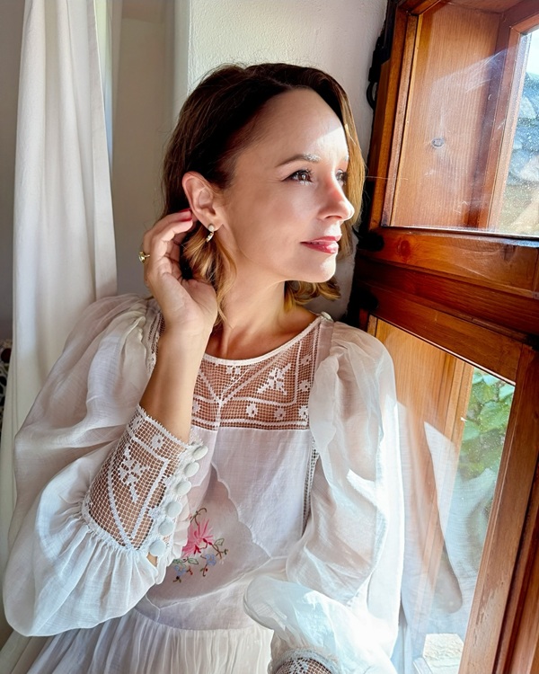 andreea marin imbracata in alb se uita pe geam