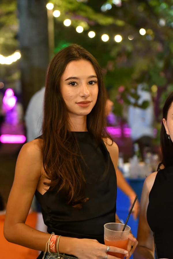 stefania uta cu parul desprins in rochie neagra cu pahar de suc in mana