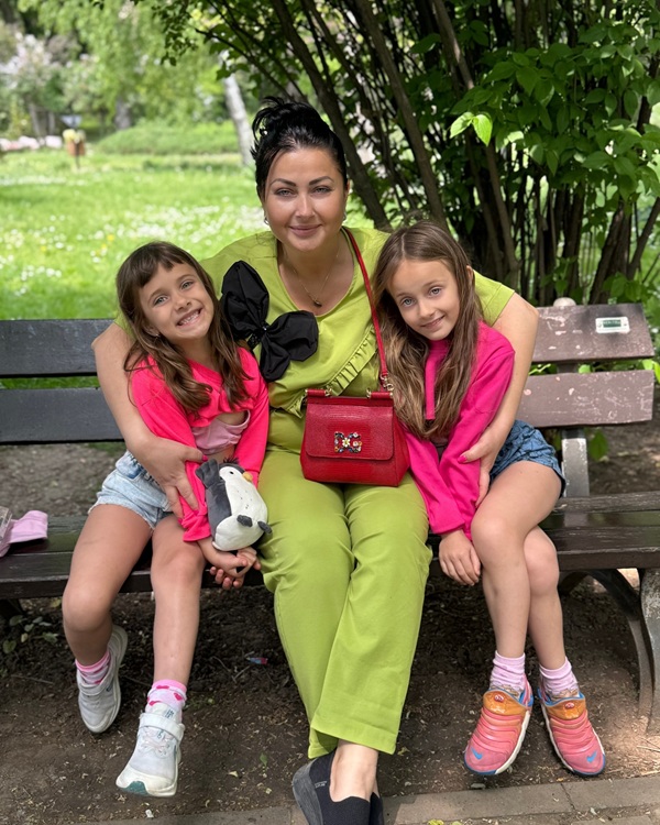 gabriela cristea cu fiicele ei pe o banca in parc