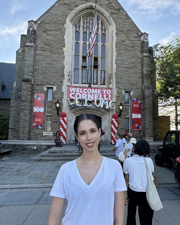 violeta banica in bluza alba in fata universitatii cornell