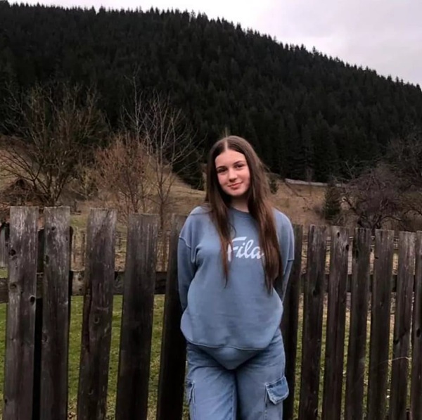 fata cu parul lung imbracata in albastru pe munte