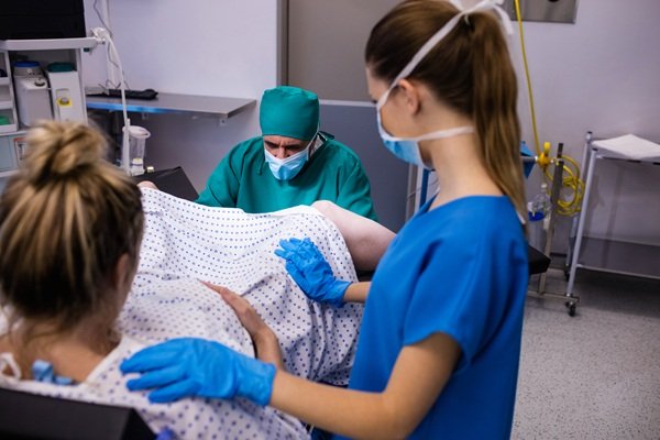 medic si asistenta asista la nastere intr-un spital