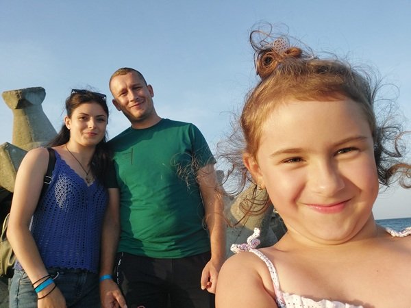 alina bahrim in maieu albastru crosetat impreuna cu sotul si fetita care le face selfie