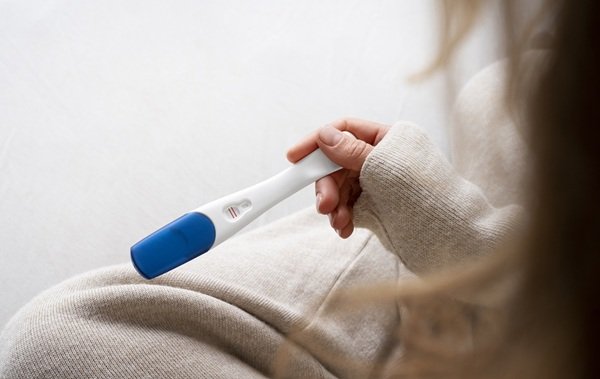 femeie tine un test de sarcina in mana