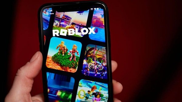 mana de adult ce tine un telefon cu jocul roblox