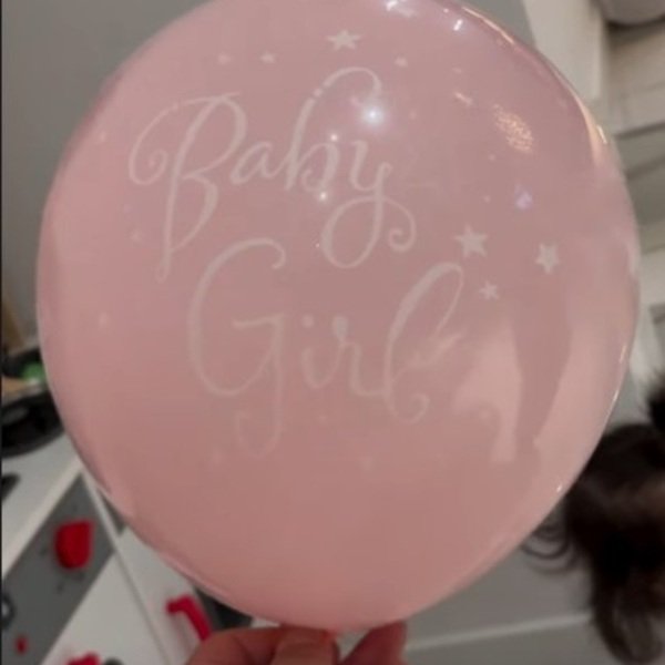 balon roz pe care scrie in engleza este fetita