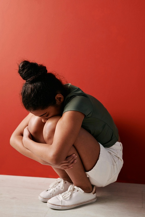 fata cu parul prins in coc sta ghemuita