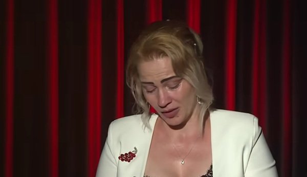 femeie blonda cu sacou alb plange