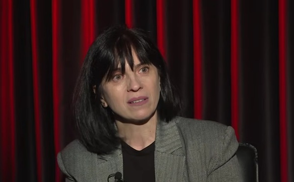 femeie bruneta cu parul scurt si sacou gri