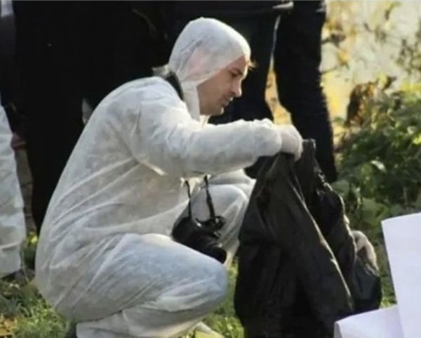 barbat imbracat in costum alb tine o geaca in mana