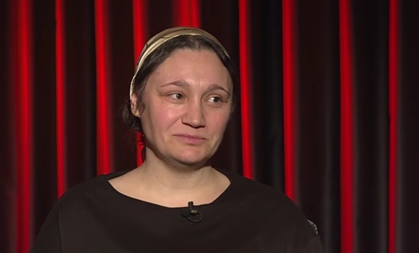 femeie cu bluza maro si parul prins in batic