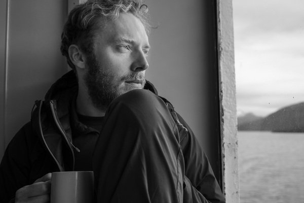 barbat tine o cana in mana si se uita pe fereastra