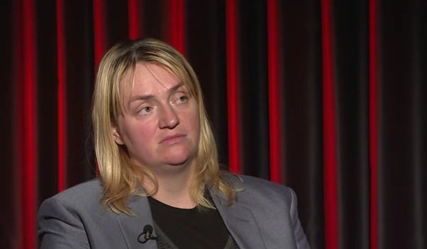 femeie blonda tunsa scurt in sacou gri