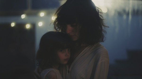 femeie tine o fetita in brate si plange