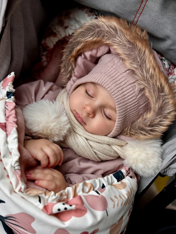 copil doarme in carut in geaca de iarna cu fular