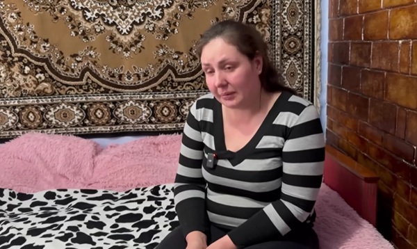 femeie in bluza cu dungi alb si negru sta pe un pat