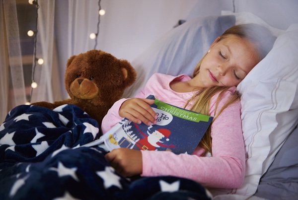 fata doarme cu o carte de povesti in brate