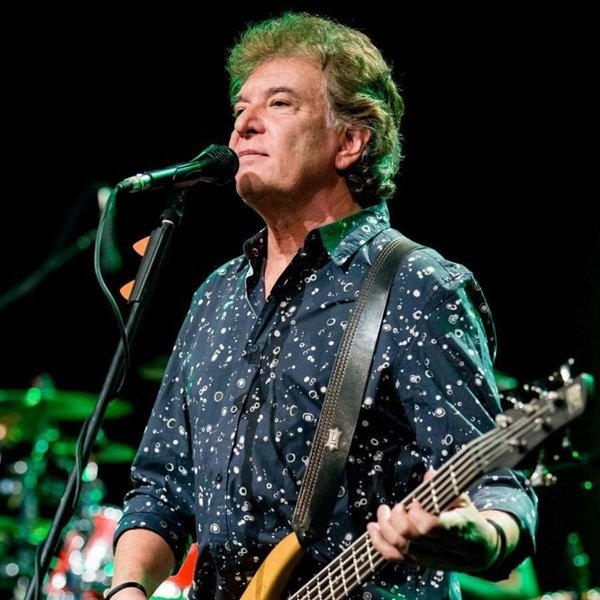 iulian vrabete in camasa albastra cu model negru cu basul in mana