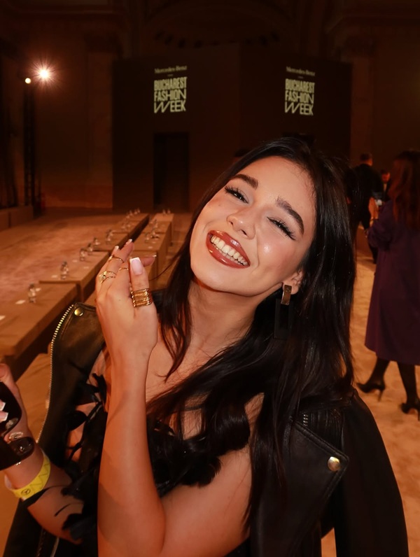 ianca simion cu parul lung si buzele rosii zambeste imbracata in negru